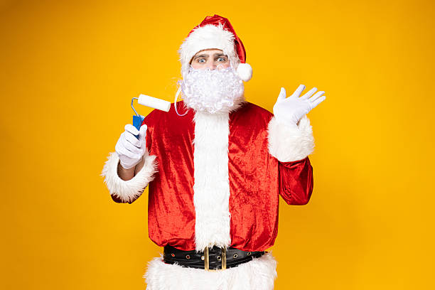 istock Santa Claus makes repairs on a yellow background. 2234229874