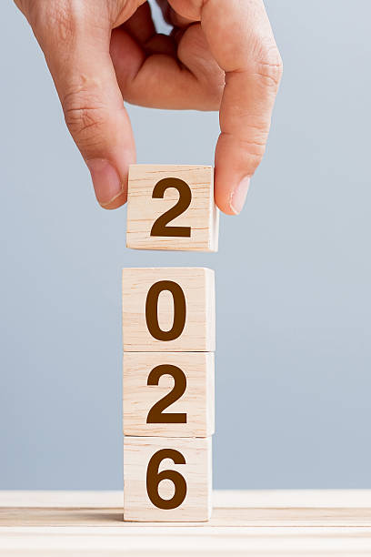 istock hand holding wooden cube block with 2026 text on table background. Resolution, plan, review, goal, start and New Year holiday concepts 2234230163