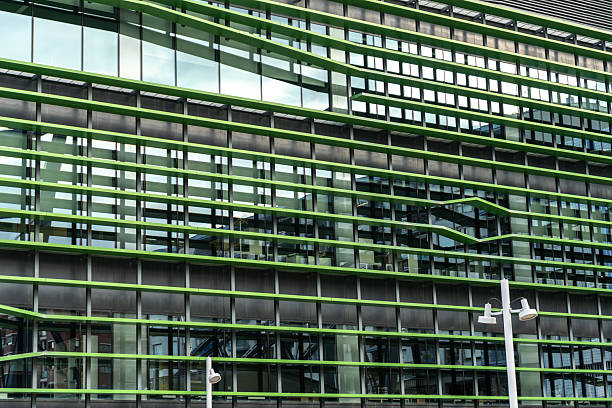 Bilbao, Spain, March 28, 2024: Modern glass building with green facade in Bilbao's riverside district with geometric design, editorial image