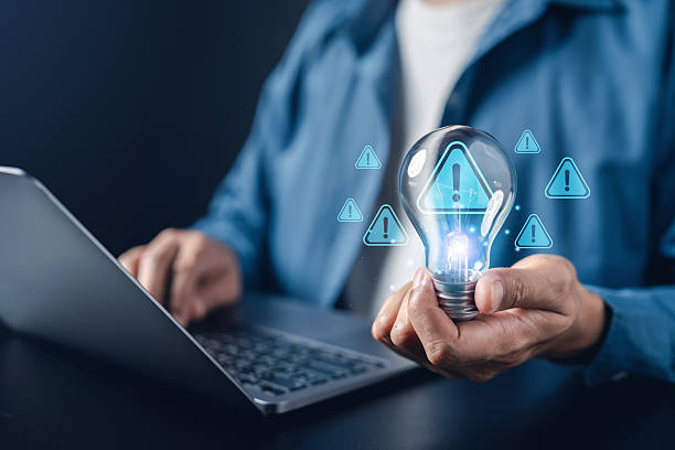 istock Cybersecurity alert, data warning, risk management, and innovation safety with person holding light bulb danger, system vulnerability, and information security. 2234238665