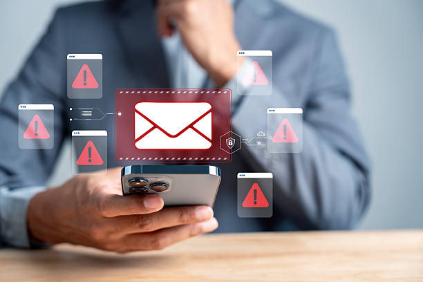 istock Email warning danger. Man checking smartphone with red alert email. phishing scams, email threats, cybersecurity risk, and online fraud prevention. 2234238682