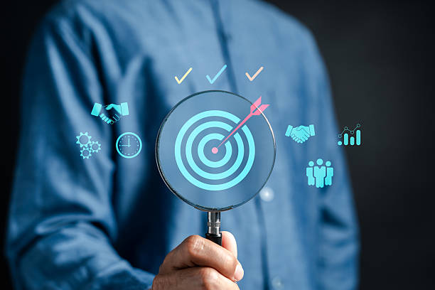 Business target setting and goal achievement. magnifying glass focused on dartboard productivity, teamwork, and performance strategy.