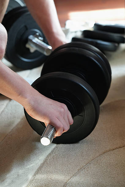 istock Closeup dumbbell, which a man holds by the handle 2234243081