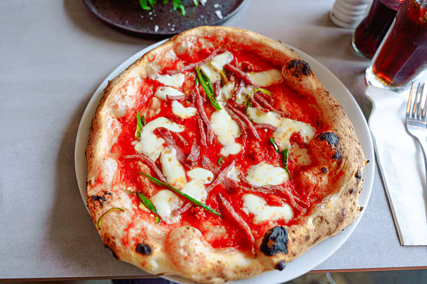 istock Pizza with fresh ingredients and melted cheese served on a plate at a casual dining restaurant during lunchtime 2234244921