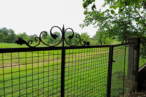 White fence enclosure in green park with pathway and grass.