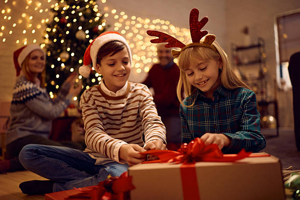 istock Happy kids opening Christmas present at home. 2234246375