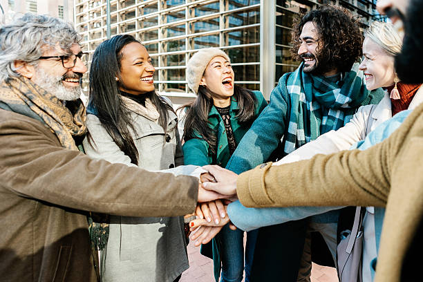 istock Group of business people stacking hands over corporate office building 2234246685