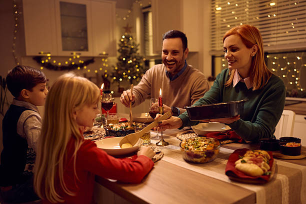 istock Happy family eating Christmas dinner at dining table. 2234246915