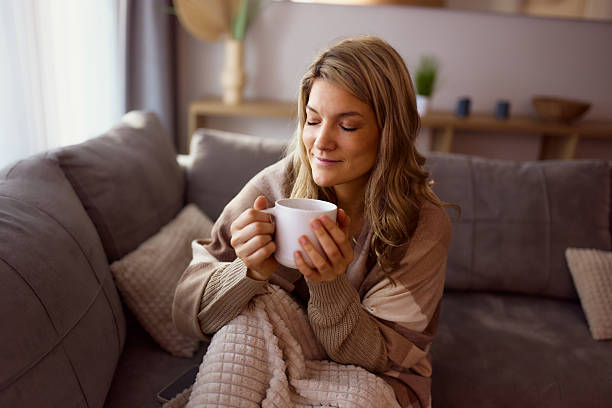 istock Relaxed woman enjoying in coffee time on sofa at home. 2234247110