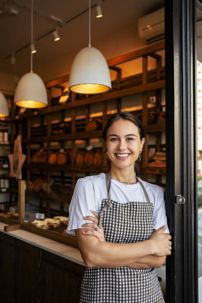istock Smiling woman baker standing at bakery doorway 2234250014