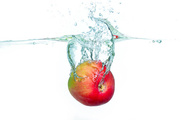 Fresh Red Apple Splashes Into Clear Water Creating Bubbles