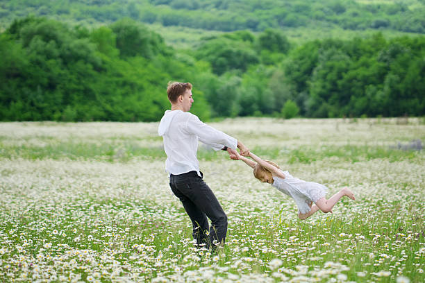 istock Happy father play with daughter in chamomile meadow 2234255409