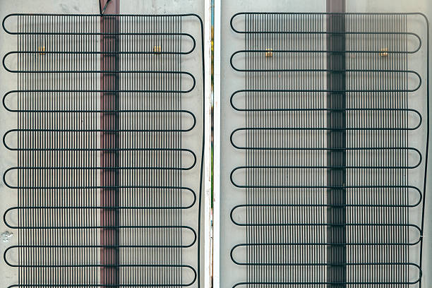 istock Metal grid condenser coils on refrigerator back panel, showing industrial structure and functional cooling system 2234255418