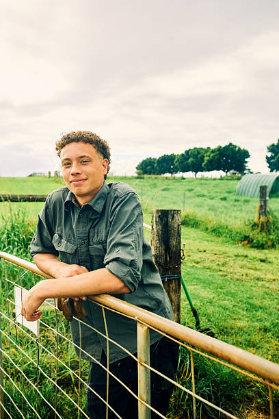 istock Young farmer leaning on gate in lush green field 2234262194
