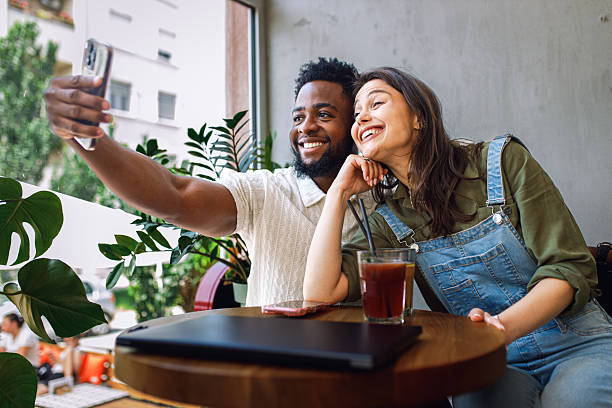 istock Happy young couple relaxing and talking while sitting together in cozy modern cafe. 2234262459