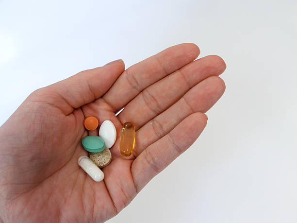 istock hand holds various medications capsules, vitamin, supplements 2234264548