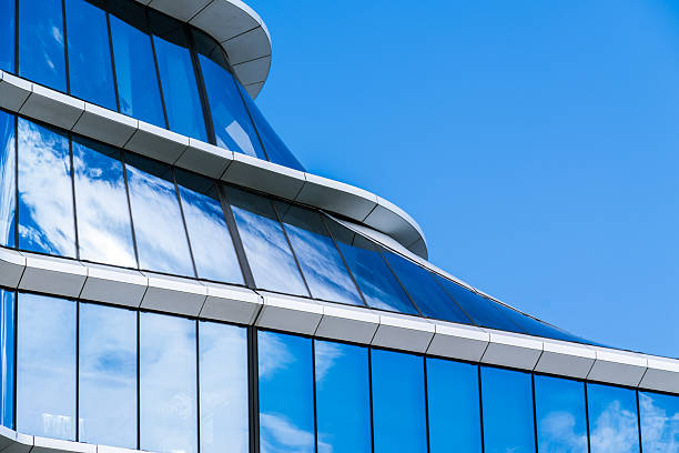 istock Futuristic office building with curved white structures and reflective blue glass creating fluid, modern architectural design. 2234265017