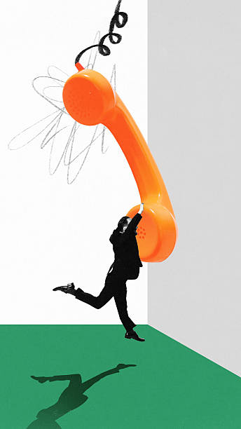 istock Businessman hanging from oversized orange phone in surreal collage 2234267361