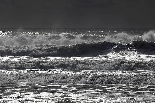 istock Dramatic black and white waves crash against rocky shores under a moody sky 2234267429