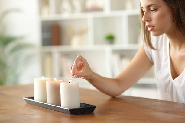 istock Woman lighting aromatic candles at home 2234270135