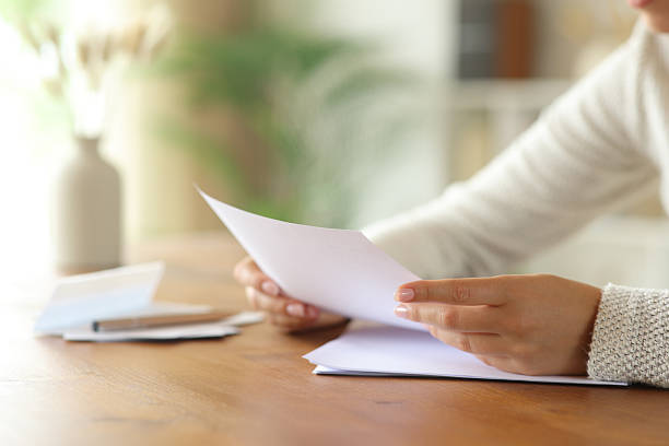 istock Woman hand reading card on table in a house interior 2234270186