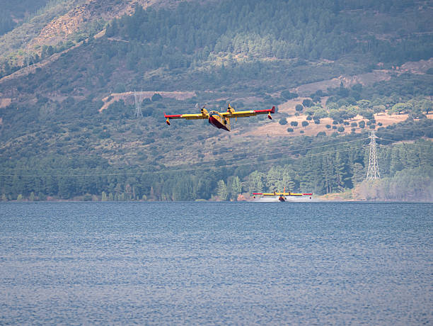 Ponferrada, Leon, Spain; 08-20-2025: Two Italian seaplanes (CL-415) perform a water-collection maneuver at the Bárcena reservoir to help extinguish the forest fires in Galicia and El Bierzo in 2025