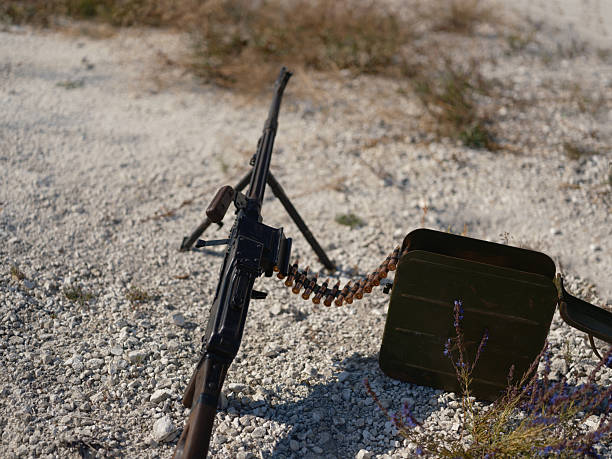 istock Heavy machine gun with ammunition belt on the ground 2234272326