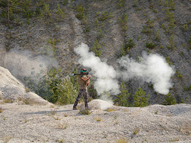 Full-body soldier in military gear shooting a grenade launcher with thick smoke coming from the barrel on white chalk terricons.