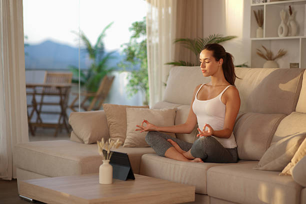 istock Yogi doing yoga at sunset on a couch at home 2234275159