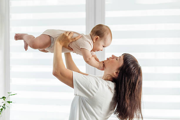 istock Mother holding baby up and playing together 2234277784