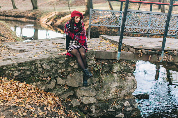 istock Young Woman Sitting on Rustic Stone Bridge in Autumn Forest 2234279934