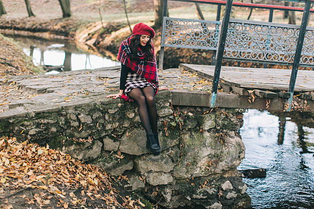 istock Young Woman Sitting on Rustic Stone Bridge in Autumn Forest 2234279944