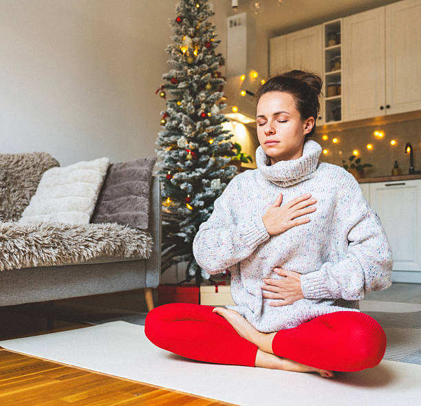 istock Woman meditating during Christmas doing relaxing breathing exercise. 2234280068