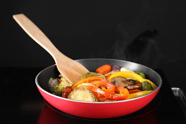 istock Frying pan with vegetables and mushrooms on stove, closeup 2234280452