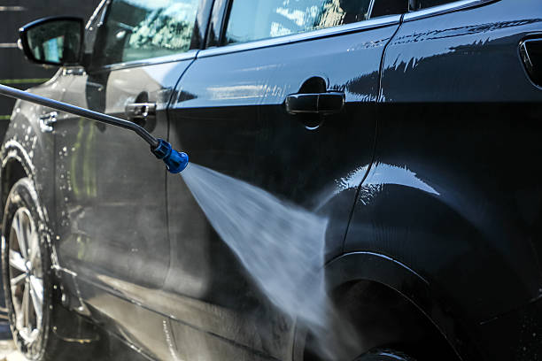 istock Car being washed under bright sunlight with a high-pressure washer, highlighting sparkling cleanliness, regular maintenance, and modern vehicle care (part of the “at the car wash” series). 2234280899