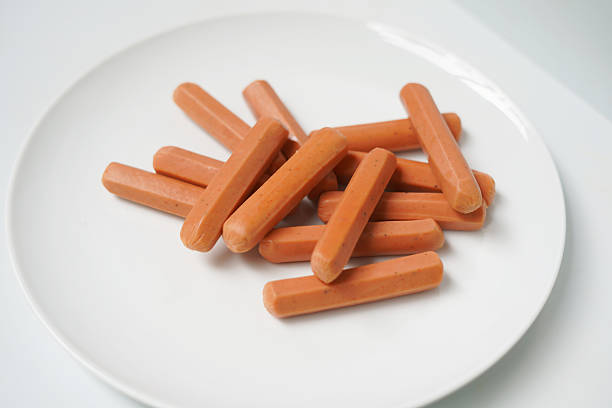 istock Uncooked Sausages on White Plate Closeup. 2234289447