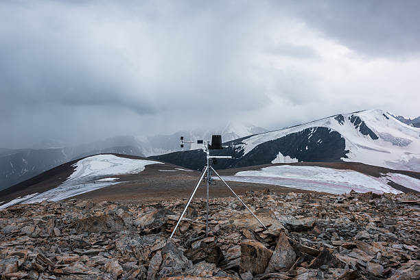 istock Automatic meteorological station on stone hill with view to large snow-capped mountain range. Measurement speed and direction of wind among glaciers. Measuring atmospheric pressure and precipitation. 2234289507