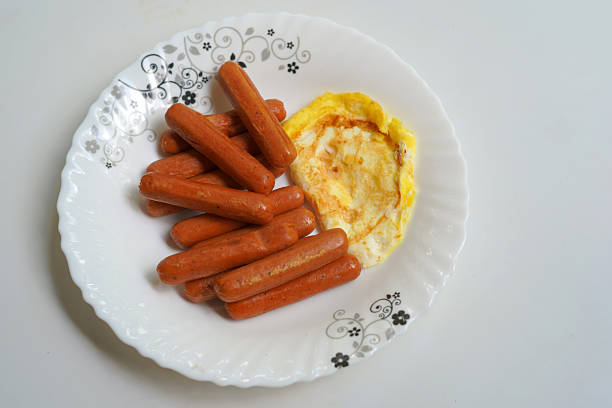 istock Fresh sausages and omelet on white dish. 2234289835