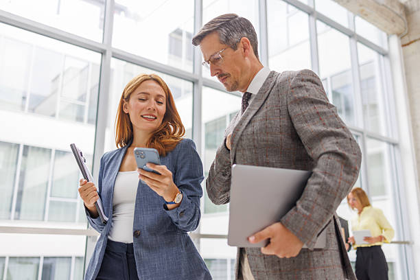istock Business colleagues sharing information using mobile phone in office 2234290851