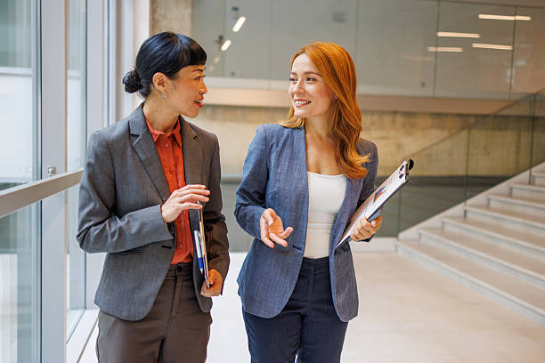 istock Two businesswomen walking and talking in modern office 2234290948