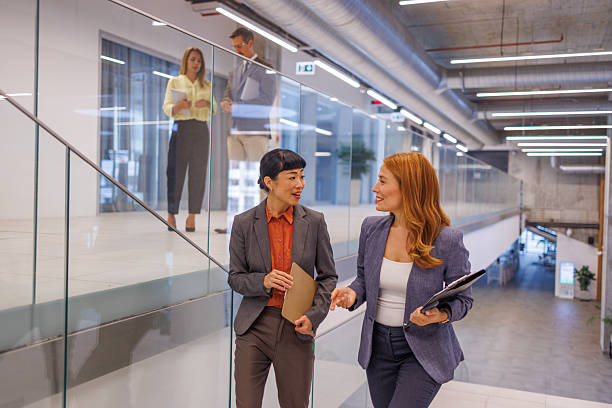 istock Businesswomen walking and talking in modern office 2234290956