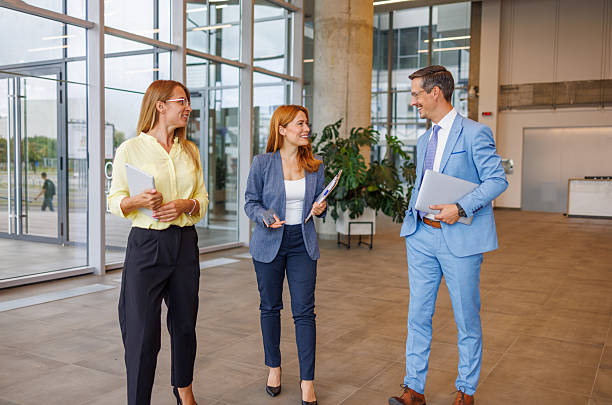 istock Businesspeople walking and talking in modern office building lobby 2234291171