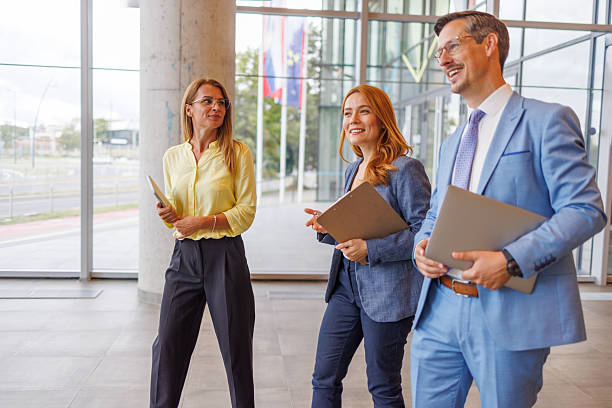 istock Businesspeople walking and talking in modern office building lobby 2234291217