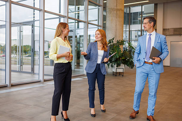 istock Businesspeople walking and talking in modern office building lobby 2234291220