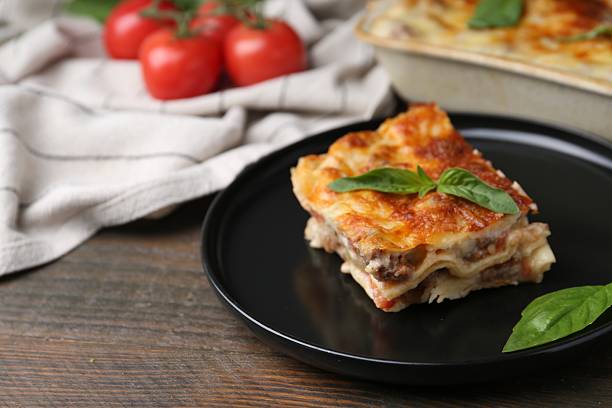 istock Delicious cooked lasagna with basil on wooden table, closeup 2234291225