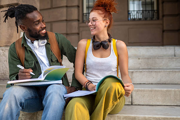 istock Multicultural students sitting together on the stairs and talking. 2234293371