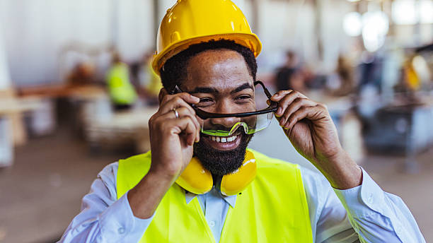 istock Smiling Construction Worker Adjusts Safety Glasses in Industrial Setting 2234294371