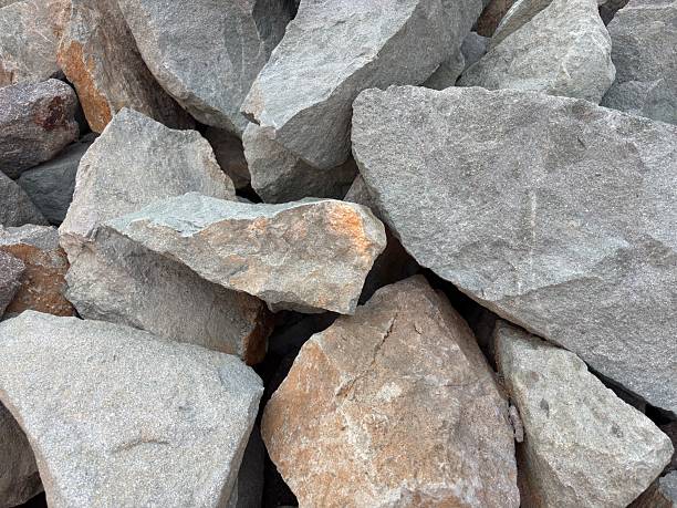 Close-up image of piled gray angular boulders. Great for use as background, texture, or detail for geology, construction, and landscape-related projects and concepts.