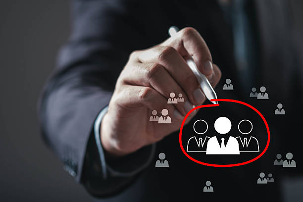 istock A hand is drawing a circle around figures, symbolizing focus on a target audience or team dynamics in a professional setting. 2234304005