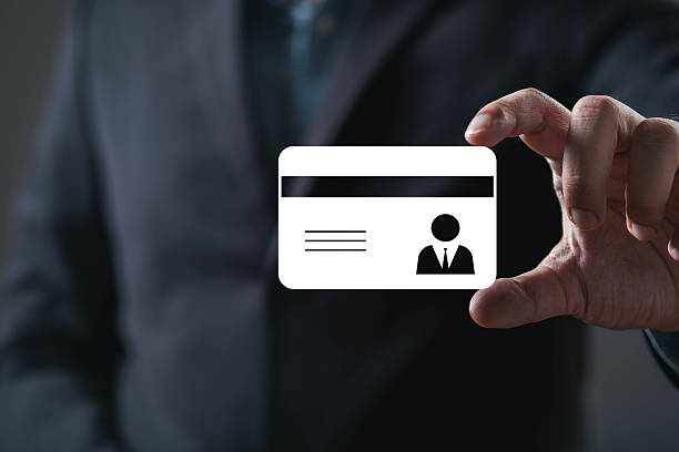 istock A person holds a blank identification card, emphasizing professionalism and identity in a dark, subdued environment. 2234304132